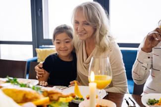 Elderly woman and grandchild having dinner together